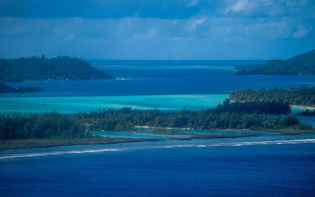 Turquoise lagune met beboste eilandjes en rif bij Bora Bora in Frans-Polynesië