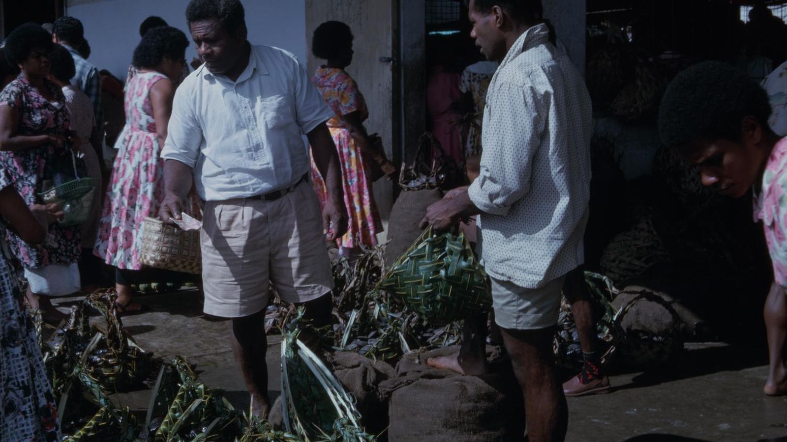 Groentemarkt in Suva met kopers en verkopers tussen stapels groenten