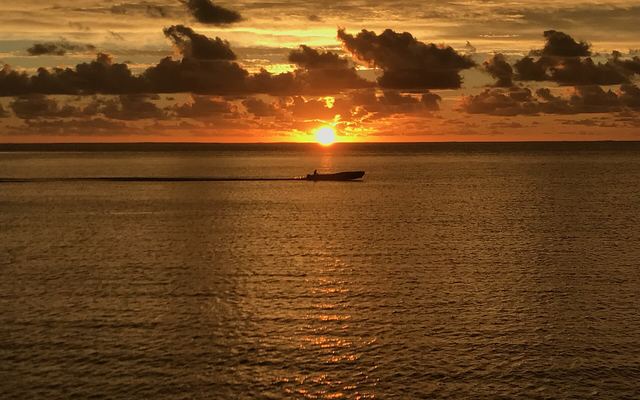 Zonsondergang boven de lagune bij Likuliku met een bootje op het water