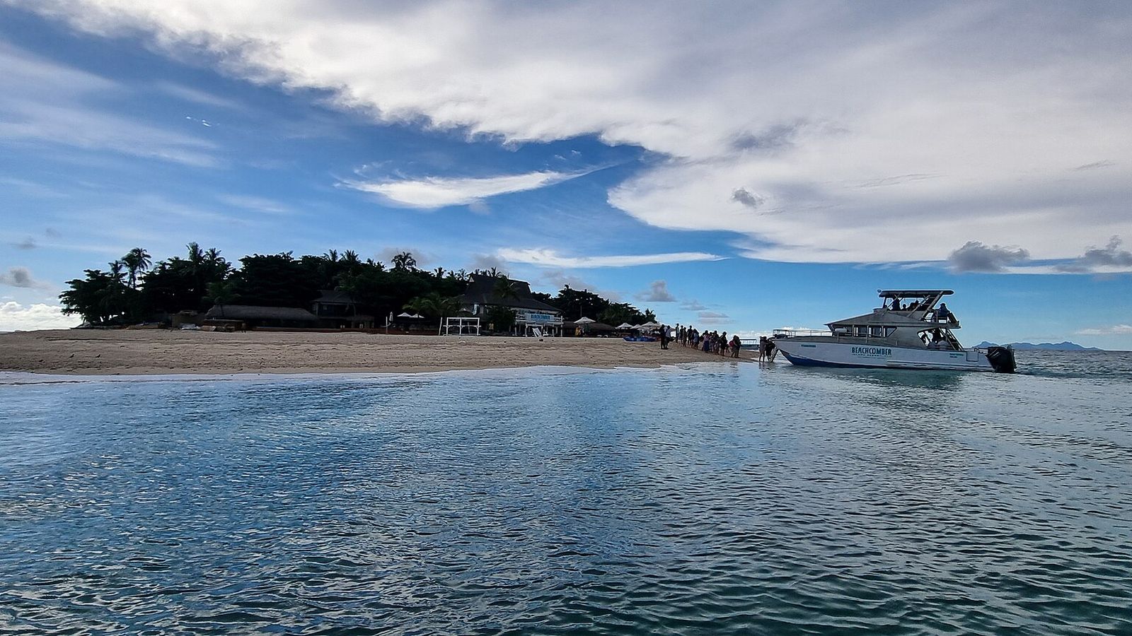 Beachcomber Island met strand, palmen en een aangemeerde boot in de Mamanuca-eilanden
