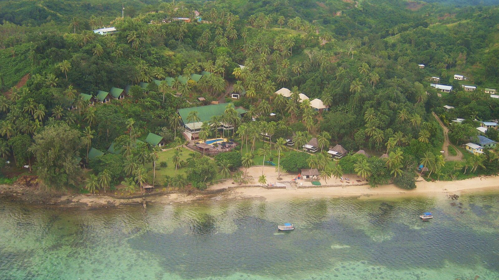 Luchtfoto van een kleinschalig resort met bungalows tussen de palmen aan de Coral Coast