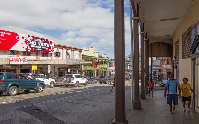 Straat in het centrum van Suva met winkels, auto's en een overdekte galerij