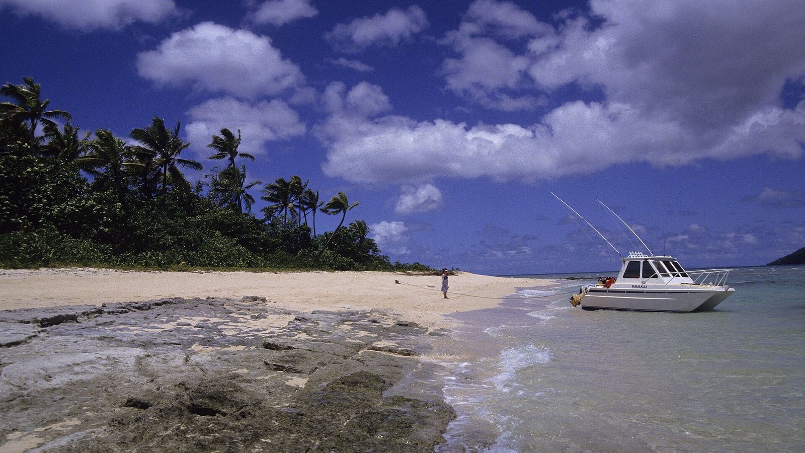 Strand met een motorboot aan de kust van Taveuni